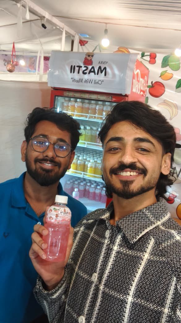 Guests holding Mastii bottles at the stall